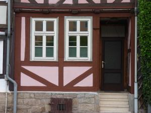 een rode deur en twee ramen op een huis bij Ferienhaus Rosa Blume in Hannoversch Münden