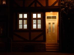 een deur en ramen van een huis 's nachts bij Ferienhaus Rosa Blume in Hannoversch Münden