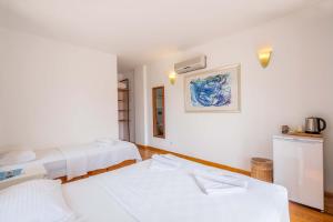 two beds in a room with white walls at Luna Kaş in Kaş