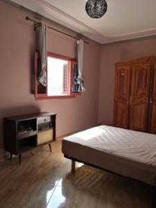 a bedroom with a bed and a dresser and a window at Family house 2 bedrooms, 2 sdb, near Center of Nador & Airport in Selouane