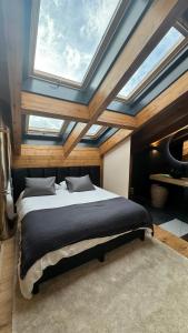 a bedroom with a large bed with a skylight at ARTYSUR LUX VILLAGE CASA 2 in Sierra Nevada