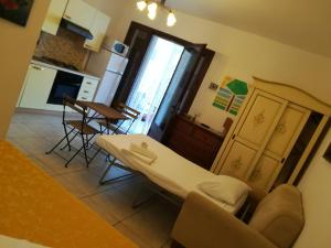 Villa Mediterranea في توري ديل أورسو: مطبخ وغرفة معيشة مع طاولة وكراسي