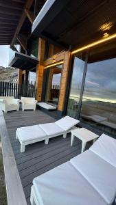 a deck with white benches and tables on a building at ARTYSUR LUX VILLAGE CASA 2 in Sierra Nevada