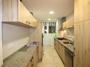 eine Küche mit Holzschränken und einer Arbeitsplatte in der Unterkunft Apartamento Roses, 3 dormitorios, 8 personas - ES-258-44 in Roses