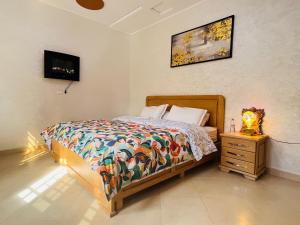 a bedroom with a bed with a colorful comforter at Magnifique Villa tout confort proche du Centre-ville in Oujda