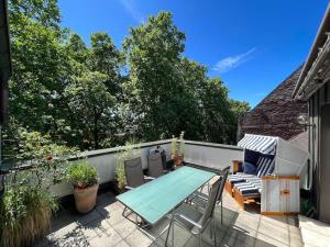 a patio with a table and chairs on a balcony at Exklusives Penthouse (72qm) - mit Terrasse im Zentrum in Cologne