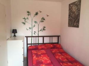 a bedroom with a bed with a red comforter and a tree mural at Exklusives Penthouse (72qm) - mit Terrasse im Zentrum in Cologne
