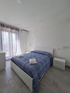 um quarto com uma cama com um edredão azul em Casa vacanze Hoffman em Caltagirone