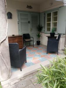 a patio with chairs and a table and a desk at Garden Budha Relax Apartman, parking, BBQ, terrace in Siófok