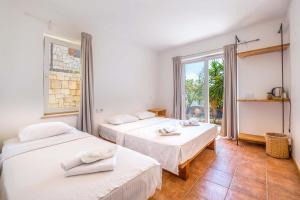 two beds in a room with a window at Luna Kaş in Kaş