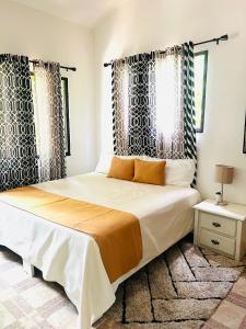 Schlafzimmer mit einem großen Bett mit schwarzen und weißen Vorhängen in der Unterkunft Casa privada 4 habitaciones aires, piscina billar agua caliente 3 minutos de la playa in Río San Juan