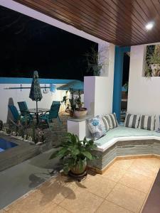 un patio con sofá, mesa y sillas en Casa privada 4 habitaciones aires, piscina billar agua caliente 3 minutos de la playa en Río San Juan