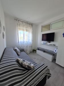 um quarto com 2 camas com almofadas e uma televisão em Casa vacanze Hoffman em Caltagirone