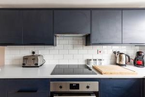 a kitchen with blue cabinets and a counter top at Modern 2-Bed Gem in Picturesque Ramsgate Central Location in Kent