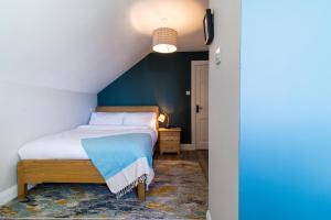 a bedroom with a bed with a blue accent wall at Port Aran House in Kilronan