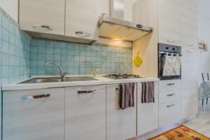 uma cozinha com um lavatório e um fogão em Trilocale Nicole - Goelba em Porto Azzurro