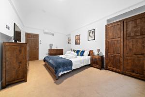 1 dormitorio con 1 cama grande y armarios de madera en Apartment 2, 48 Bishopsgate by City Living London en Londres