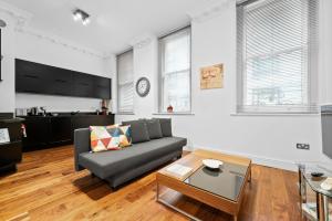 a living room with a couch and a table at Apartment 2, 48 Bishopsgate by City Living London in London