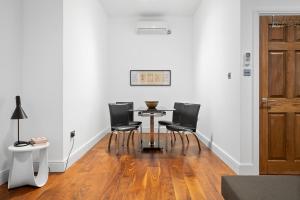 a dining room with a table and black chairs at Apartment 2, 48 Bishopsgate by City Living London in London