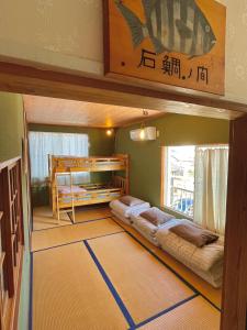 Habitación con 2 literas y ventana en ゲストハウス千倉のおへそ, en Chikura