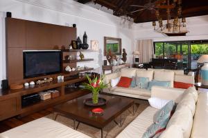 - un salon avec un canapé et une télévision dans l'établissement Villa Kaz' Grenadine, à Bel Ombre