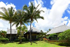 une maison avec deux palmiers devant elle dans l'établissement Villa Kaz' Grenadine, à Bel Ombre