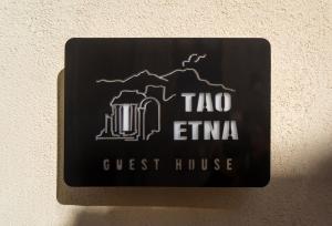 陶爾米納的住宿－TaoEtna Guest House, Taormina，墙上的黑色标志与旅馆