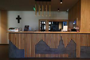 a bar in a restaurant with a cross on the wall at Casa Calfelor Kolping Timișoara in Timişoara