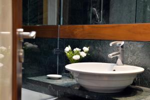 La salle de bains est pourvue d'un lavabo et de fleurs sur un comptoir. dans l'établissement Athenaeum Eridanus Luxury Hotel, à Athènes