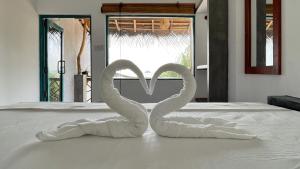 two swans made out of towels on a bed at Heimathafen Hikka in Hikkaduwa