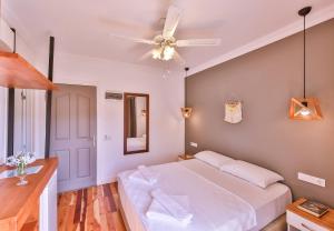 a bedroom with a white bed and a ceiling fan at Luna Kaş in Kaş