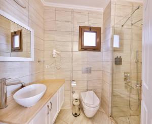 a bathroom with a sink and a toilet and a shower at Luna Kaş in Kaş