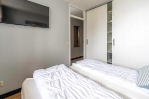 un letto bianco in una stanza con specchio di Appartementencomplex Juliana 44 a De Koog