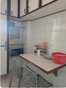 a kitchen with a table and two chairs and a refrigerator at Apartamento no Centro de Campo Grande in Campo Grande