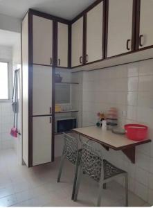 a kitchen with a wooden table and a refrigerator at Apartamento no Centro de Campo Grande in Campo Grande