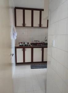 a kitchen with white tile walls and a counter at Apartamento no Centro de Campo Grande in Campo Grande