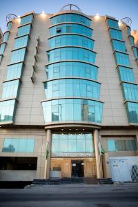 a tall building with a lot of glass windows at Golden Suites in Al Jubail