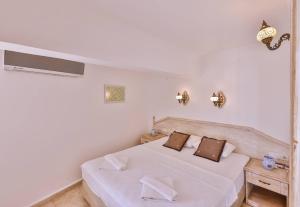 a white bedroom with a bed and a window at Luna Kaş in Kaş