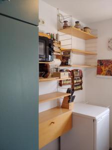 a kitchen with wooden shelves and a refrigerator at Ferienwohnung am Garten in Weißenberg +16 photos