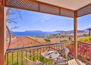 a balcony with a table and chairs and a view of the ocean at Luna Kaş in Kaş