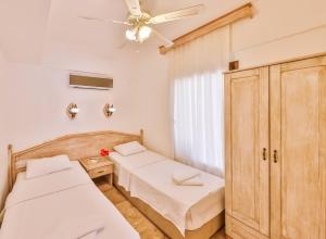a bedroom with two beds and a ceiling fan at Luna Kaş in Kaş