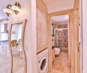 a laundry room with a washer and dryer and a mirror at Luna Kaş in Kaş