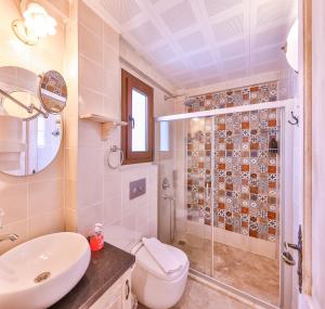a bathroom with a shower and a toilet and a sink at Luna Kaş in Kaş
