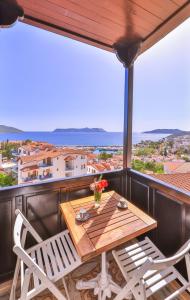 a wooden table and two chairs on a balcony at Luna Kaş in Kaş