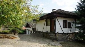 a small white house with a porch and stairs at Hadjigabarevata Kashta in Dalbok-Dol