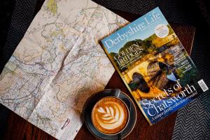 a book and a cup of coffee on a map at The Ashford Arms in Bakewell