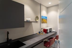 una cucina con bancone, forno a microonde e sedie di TaoEtna Guest House, Taormina a Taormina