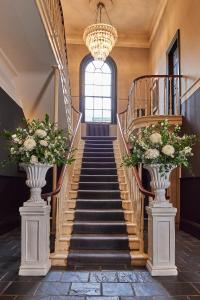 un escalier dans un bâtiment avec deux vases fleuris dans l'établissement Hotel Du Vin & Bistro York, à York