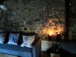 un sofá sentado en una habitación con dos velas en Genciana, Casa Rural con encanto en La Montaña Leonesa, 