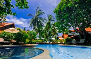 a swimming pool with chairs and umbrellas at a resort at Smile House - Fisherman Village in Bophut